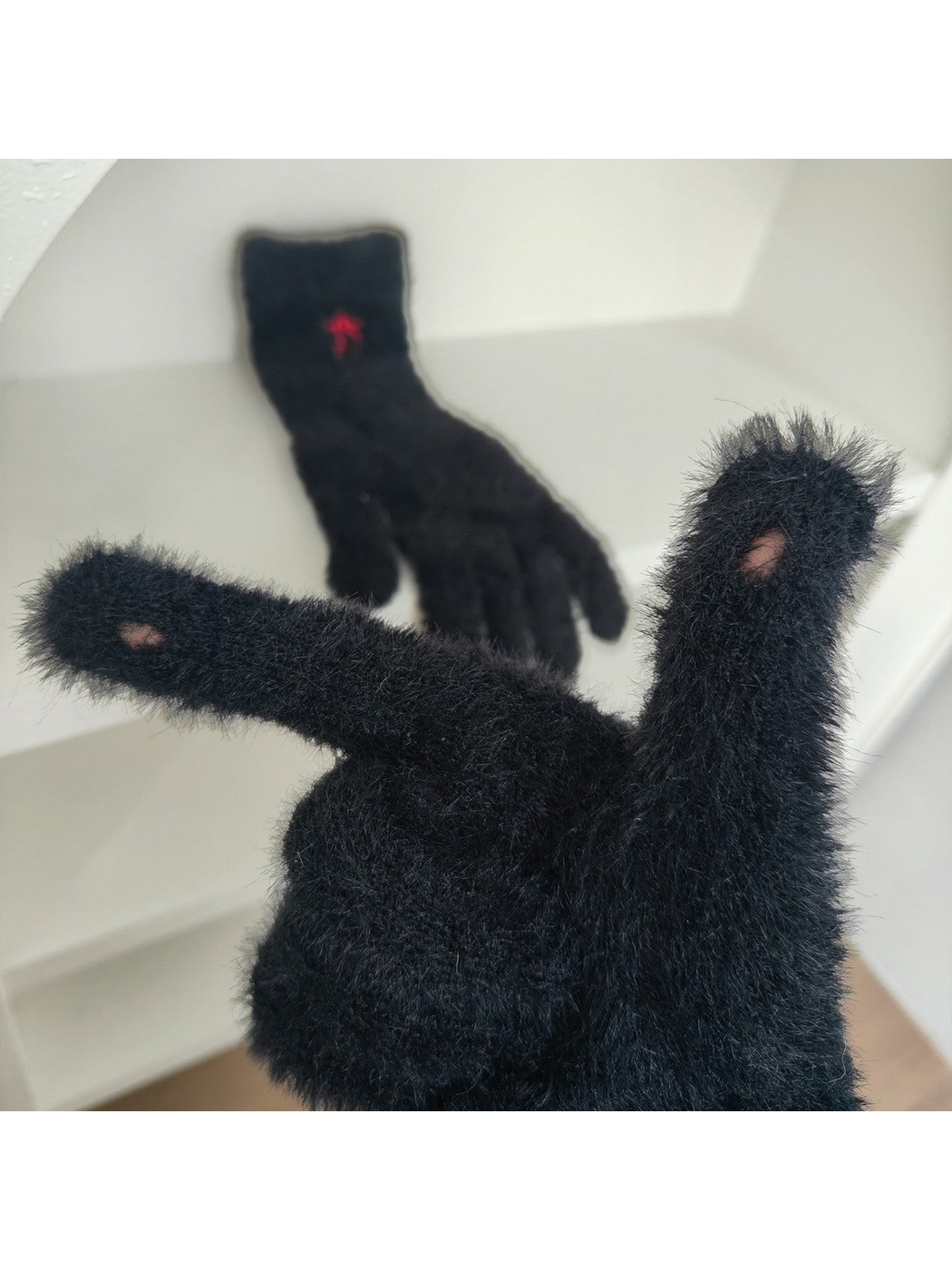 Close-up of black glove fingertip openings and fuzzy texture