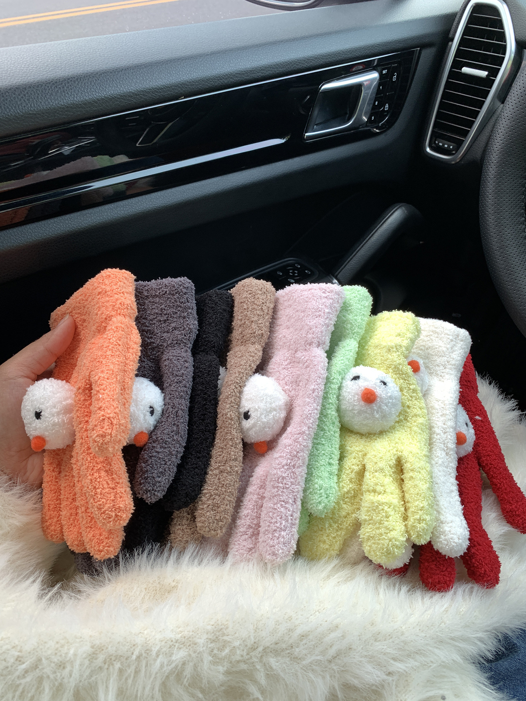 Multiple colors of fuzzy snowman-face gloves displayed together