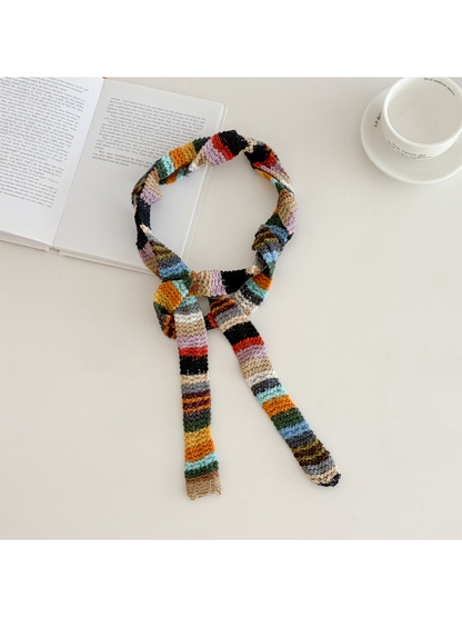 Multicolor striped narrow scarf tied loosely on a tabletop