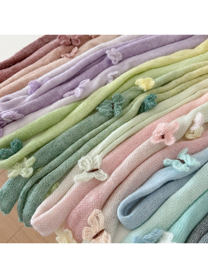 Close-up of gradient knit textures and butterfly appliqués across multiple colors