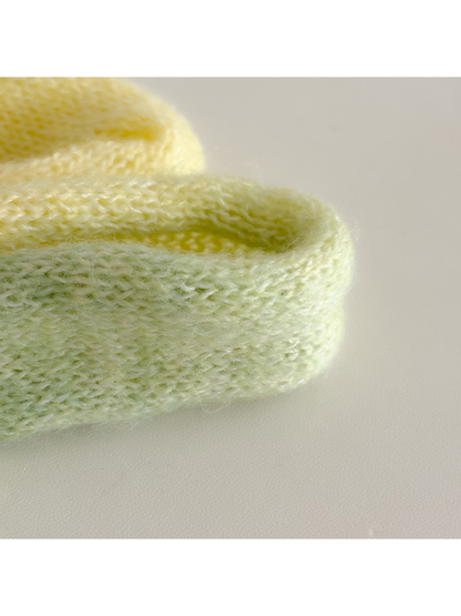 Close-up of the fuzzy knit texture and rolled scarf edges
