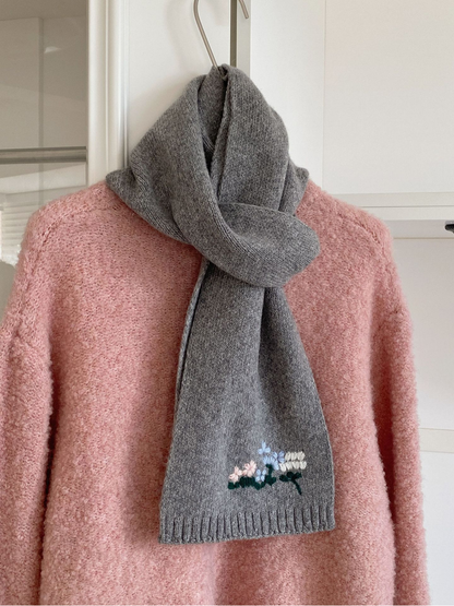 Gray floral knit scarf styled over a pink sweater