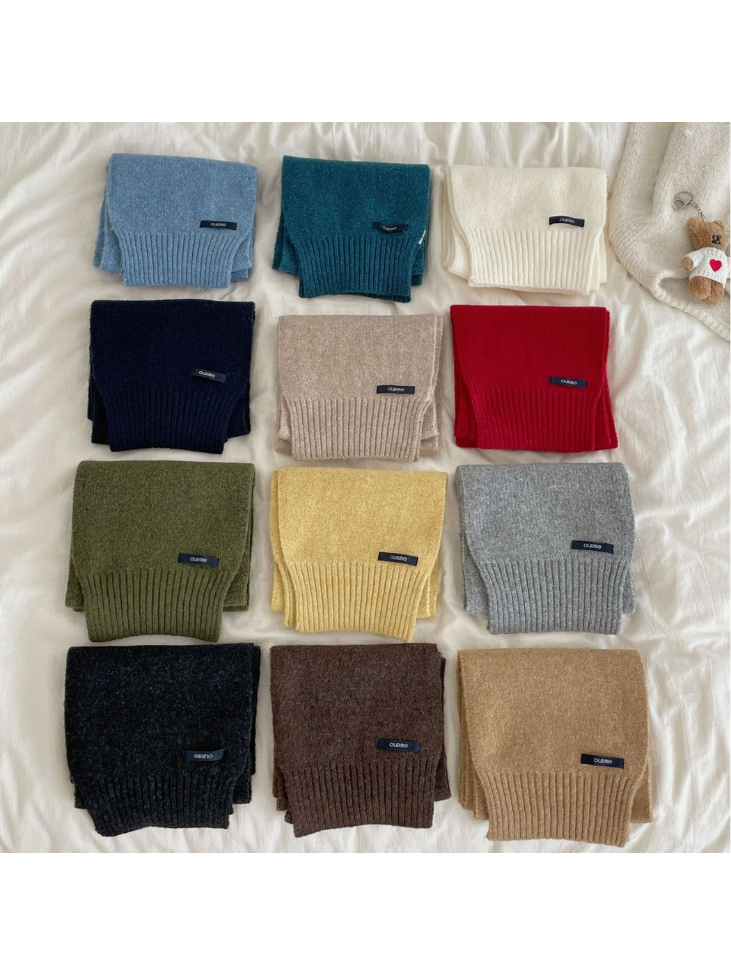 Multiple solid-color textured scarves arranged in rows