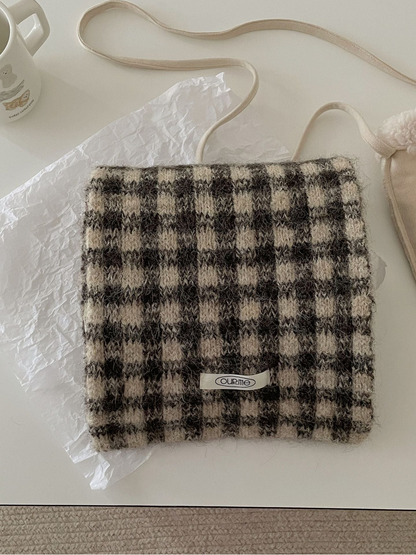 Coffee checkered scarf folded on a light tabletop