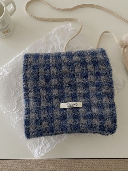 Blue Coffee checkered scarf folded on a light tabletop