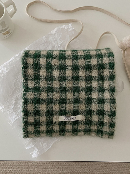 Green checkered scarf folded on a light tabletop