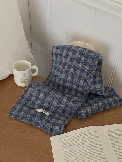 Denim Blue checkered scarf draped on a table beside a mug and open book