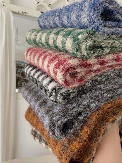 Close-up of fuzzy knit texture across stacked checkered scarves