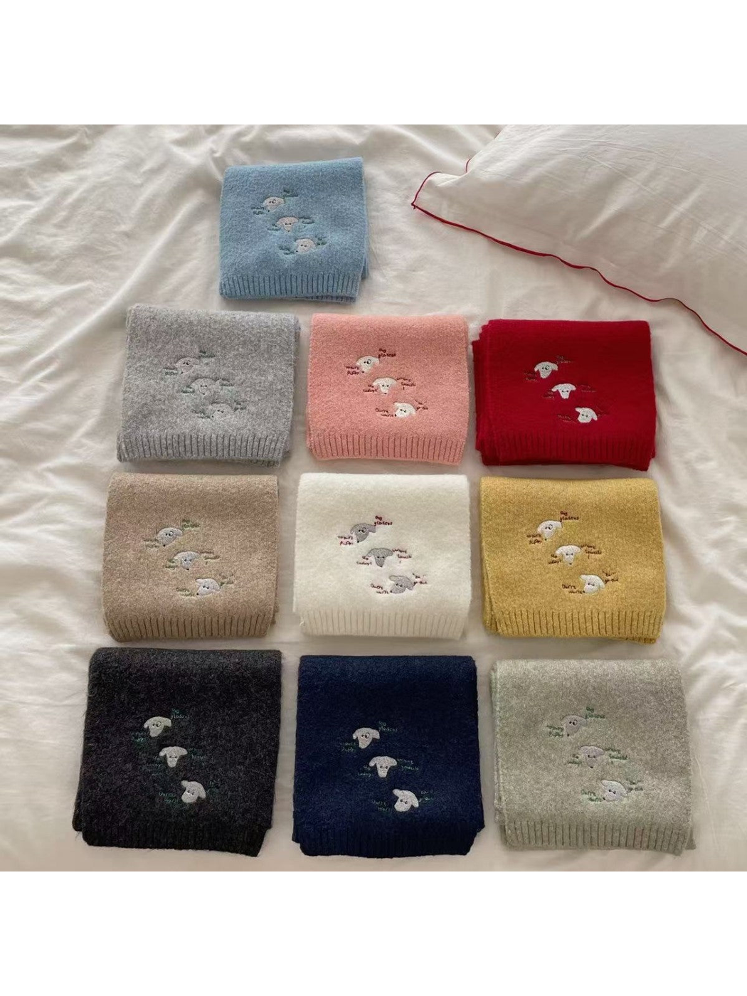 Embroidered knit scarves displayed together in multiple colors