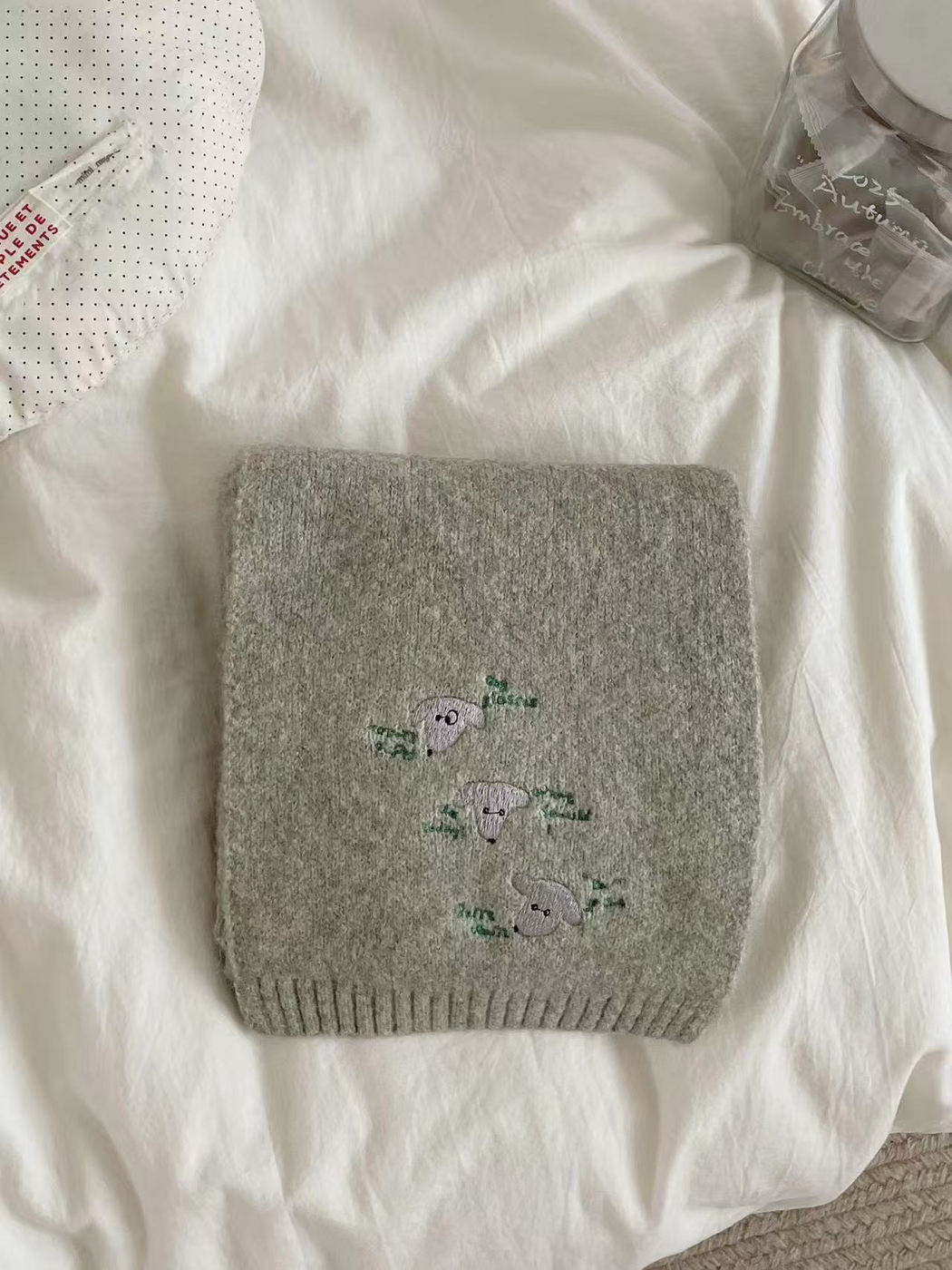 Green knit scarf with embroidered dog faces and ribbed edging