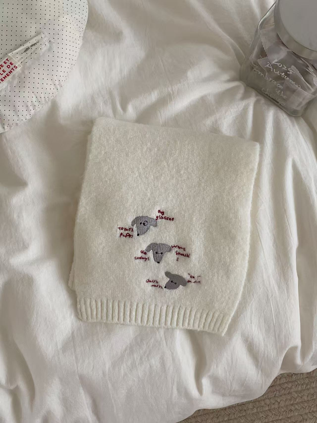 Ivory knit scarf with embroidered dog faces and ribbed edging