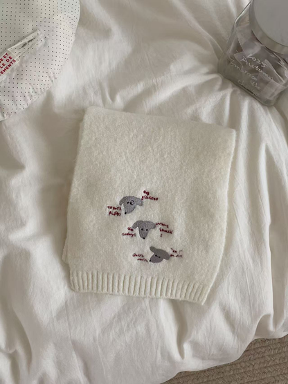 Ivory knit scarf with embroidered dog faces and ribbed edging