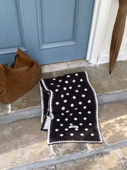 Black Ivory polka-dot scarf laid flat to show its long rectangular shape