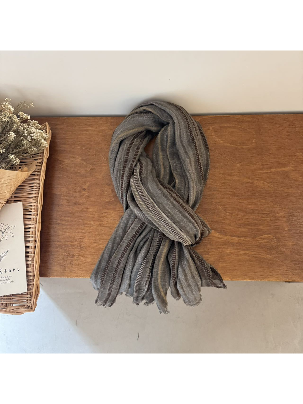 Gray striped scarf arranged in a loose draped knot