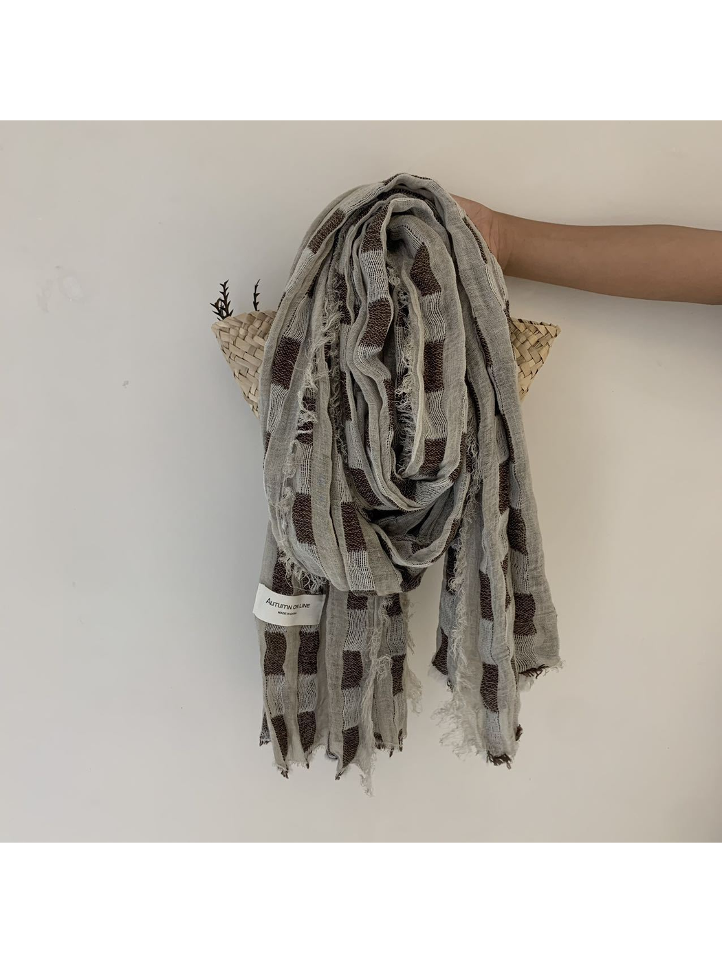 Beige scarf with rectangular block pattern and frayed edges