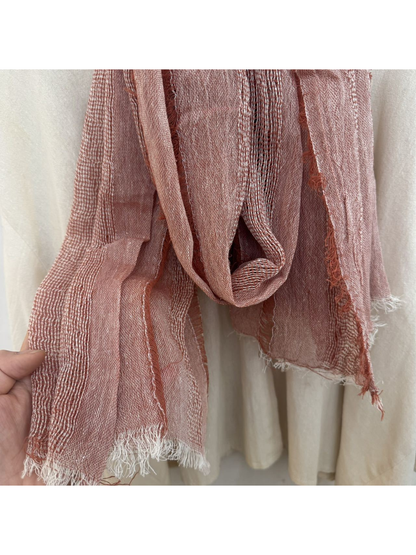 Close-up of pink scarf with alternating open-weave bands, crinkled texture and fringed edge