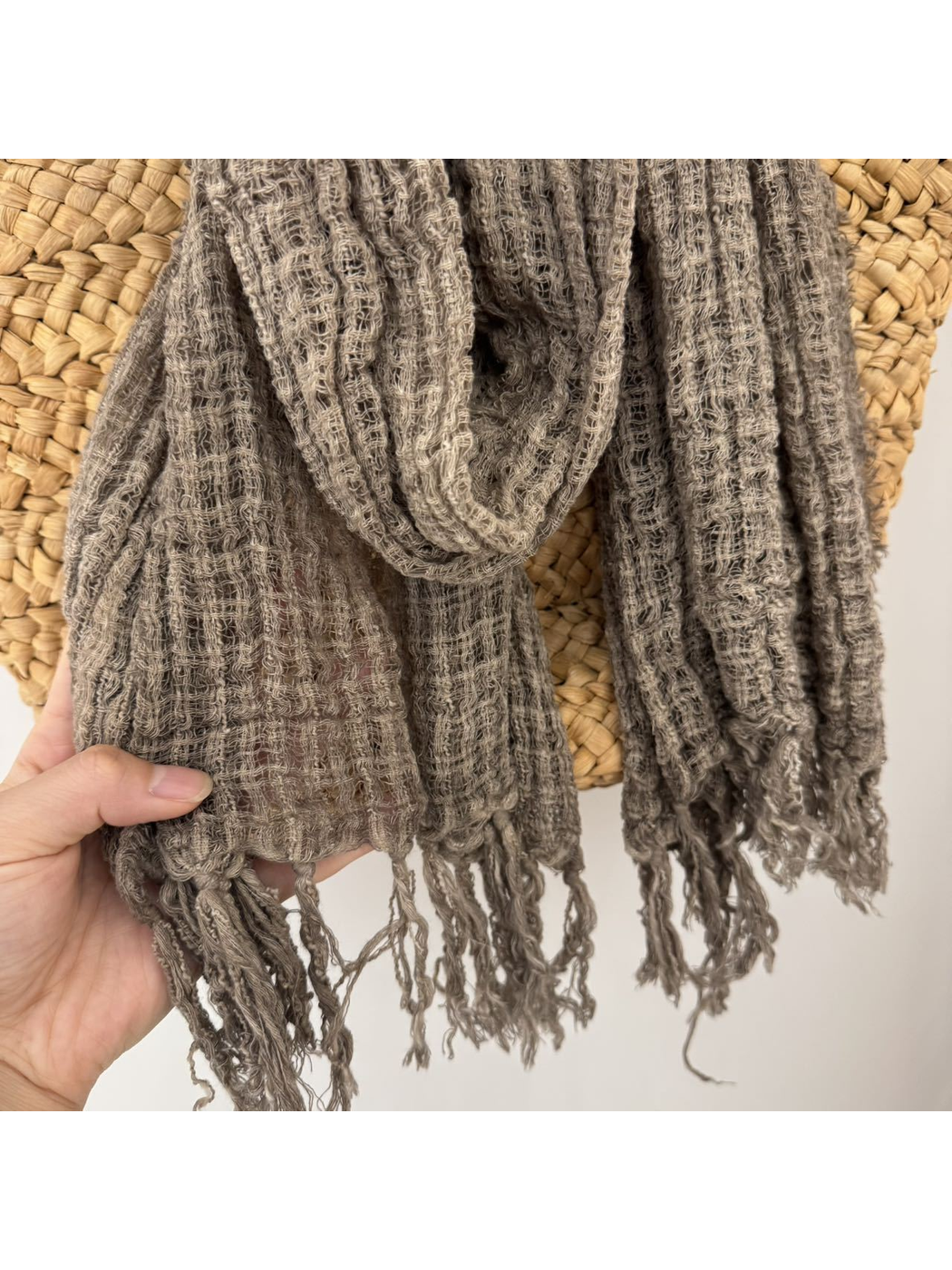 Close-up of the open-grid texture and fringed scarf ends
