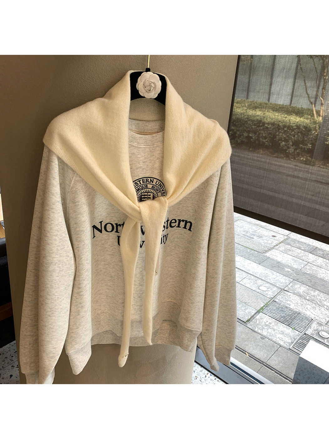 Cream triangle scarf tied over a cream sweatshirt