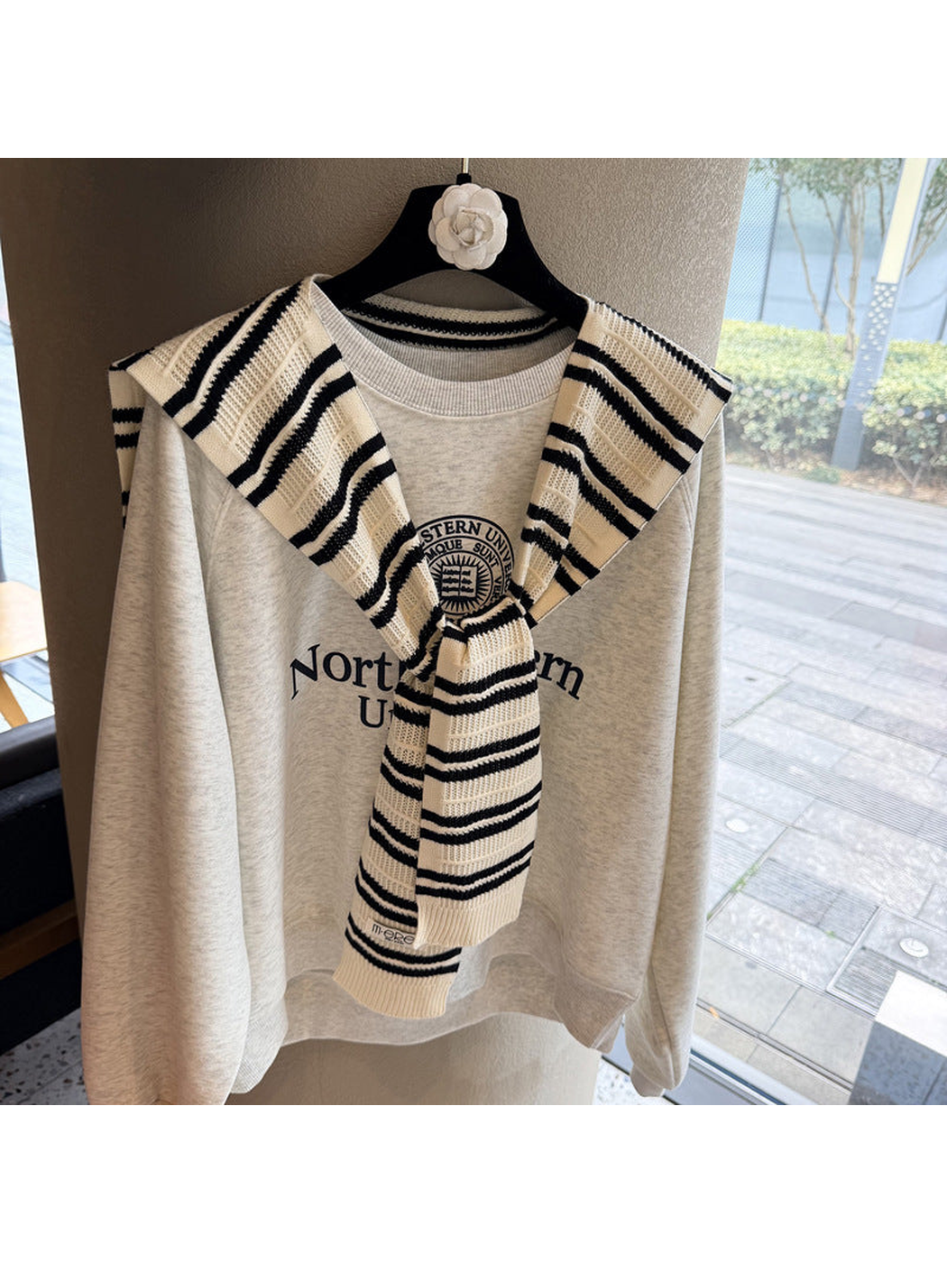 Ivory and black striped knit scarf tied over a sweatshirt