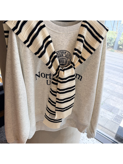 Close-up of the ivory and black stripes, openwork knit bands and tied front