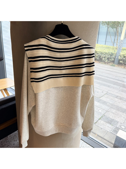 Ivory and black striped knit scarf displayed across the back of a sweatshirt