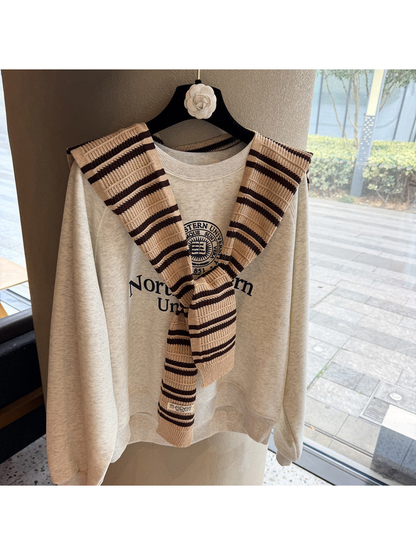 Khaki and dark brown striped knit scarf tied over a sweatshirt