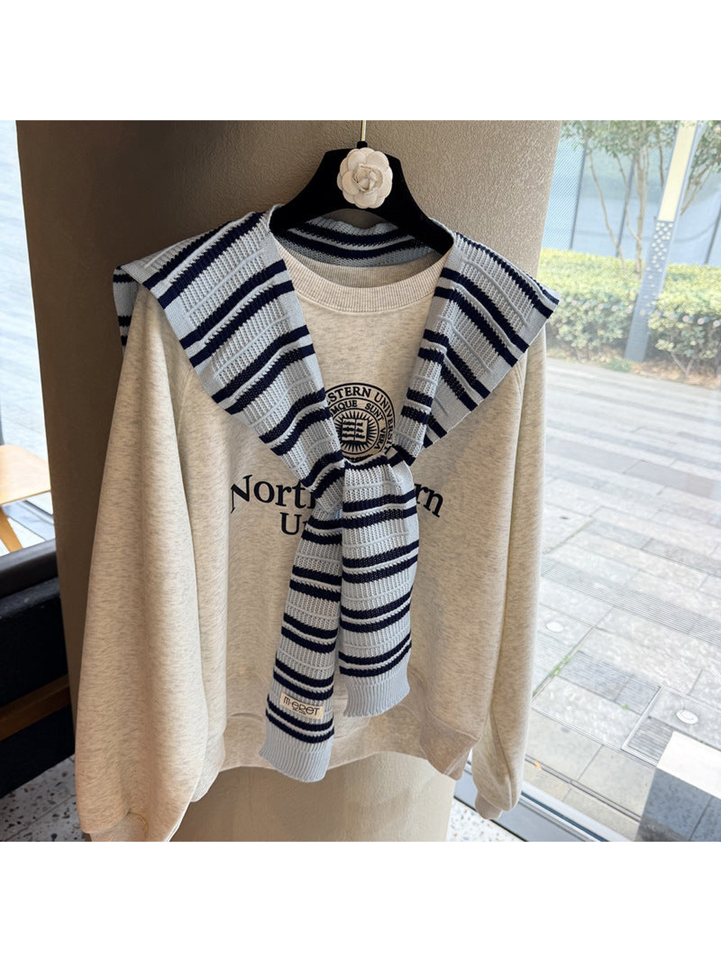 Light Blue and navy striped knit scarf tied over a sweatshirt