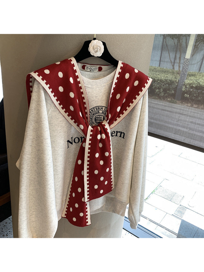 Red polka-dot scarf with contrast border in a tied front drape