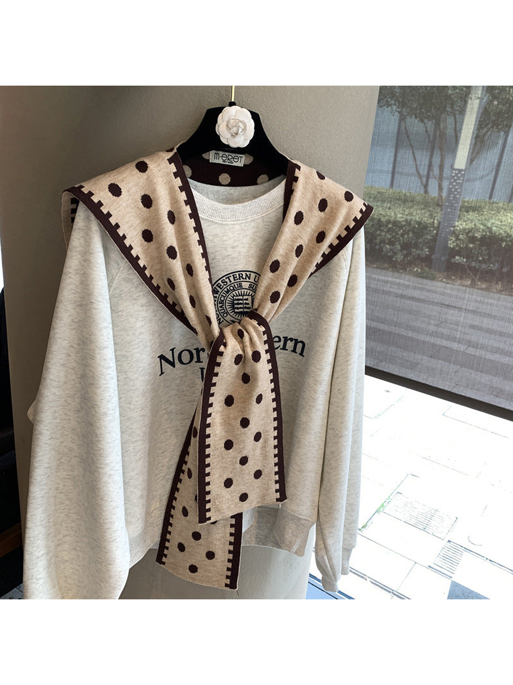 Beige polka-dot scarf with dark contrast border in a tied front drape