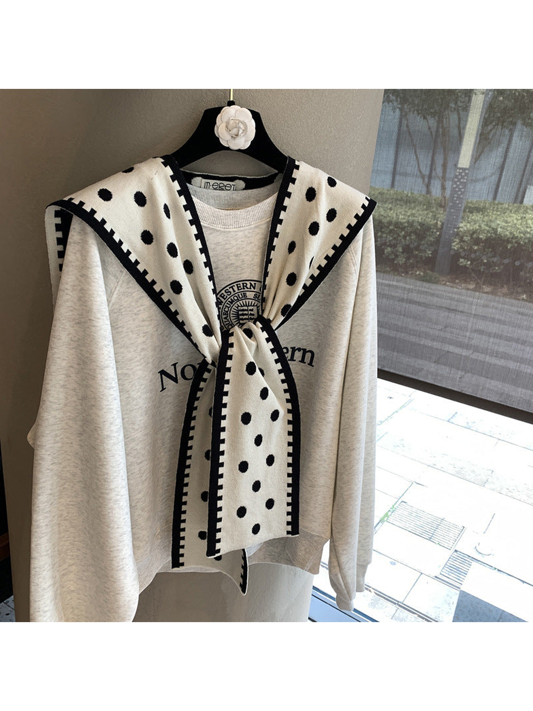 Ivory polka-dot scarf with black contrast border in a tied front drape