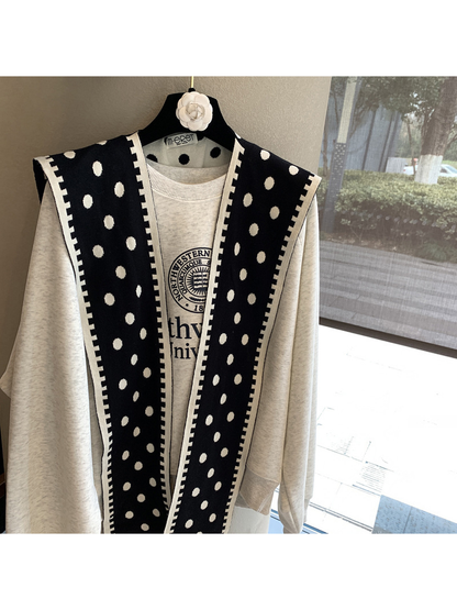 Black polka-dot scarf hanging open to show its long rectangular shape