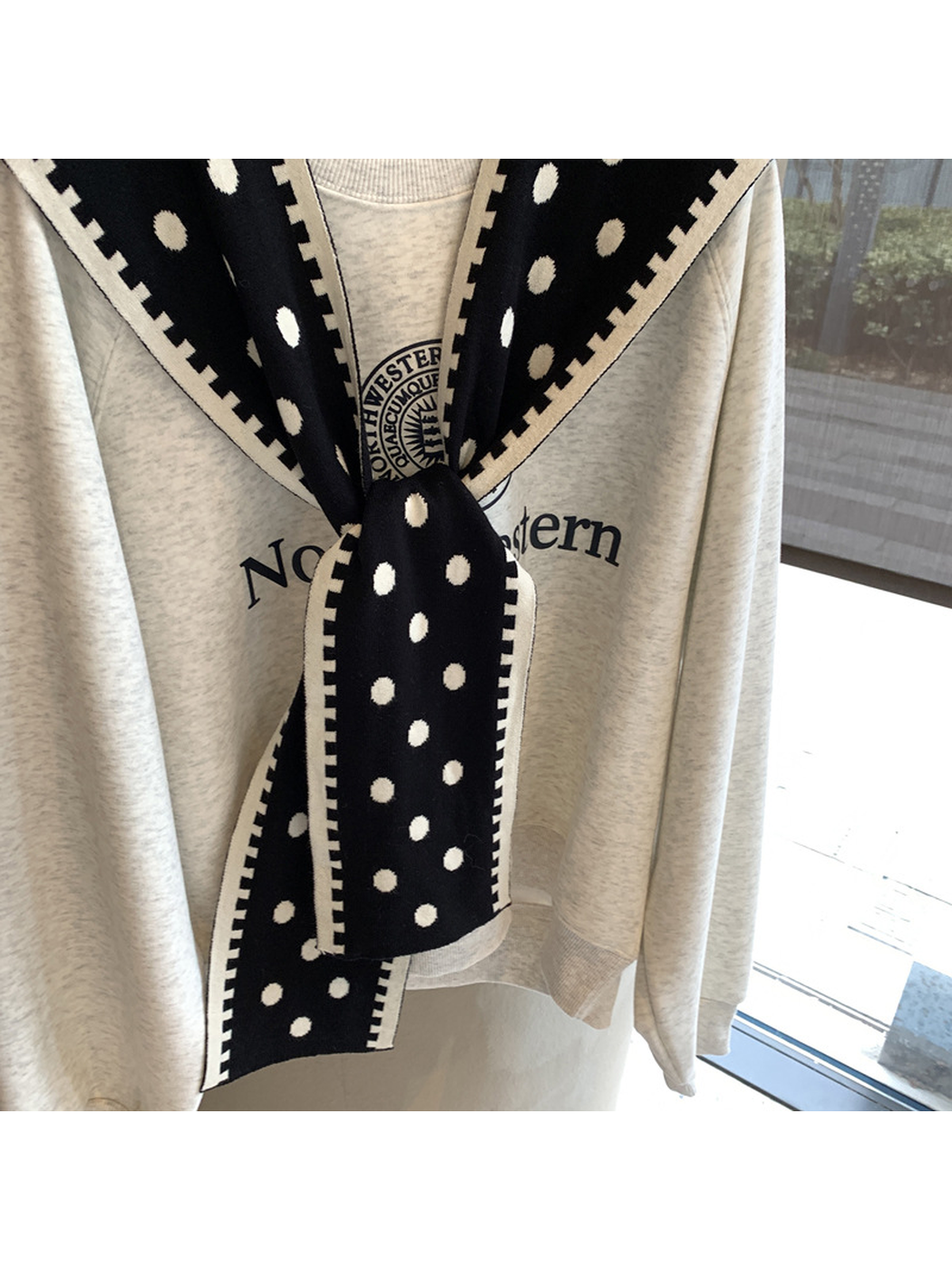 Close-up of the Black scarf's knit texture, polka dots and tied ends