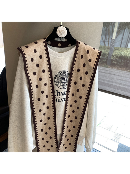 Beige polka-dot scarf hanging open to show the contrasting geometric border