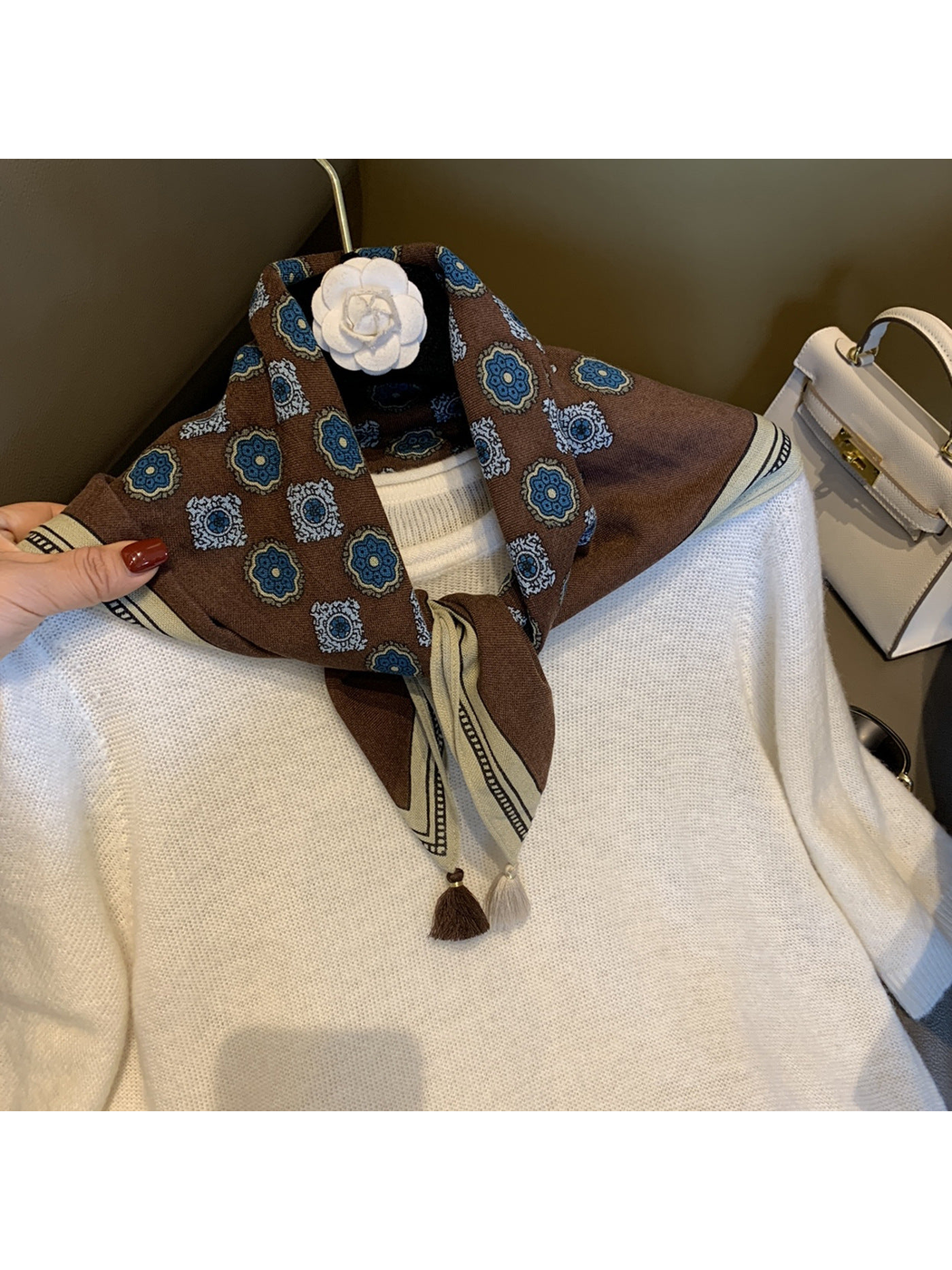 Brown square scarf with blue floral medallion pattern styled over a white top