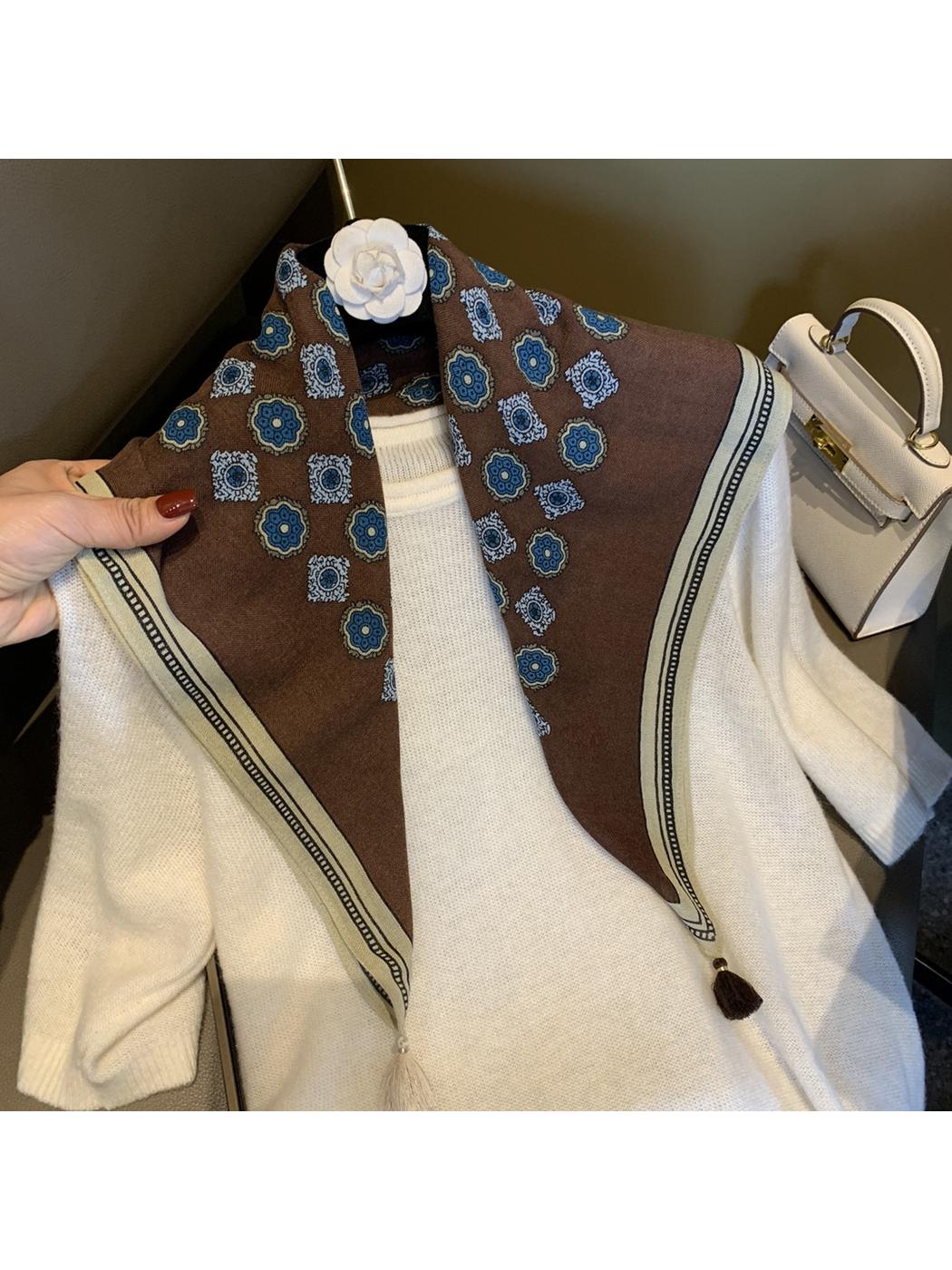 Brown floral medallion scarf draped open over a white top