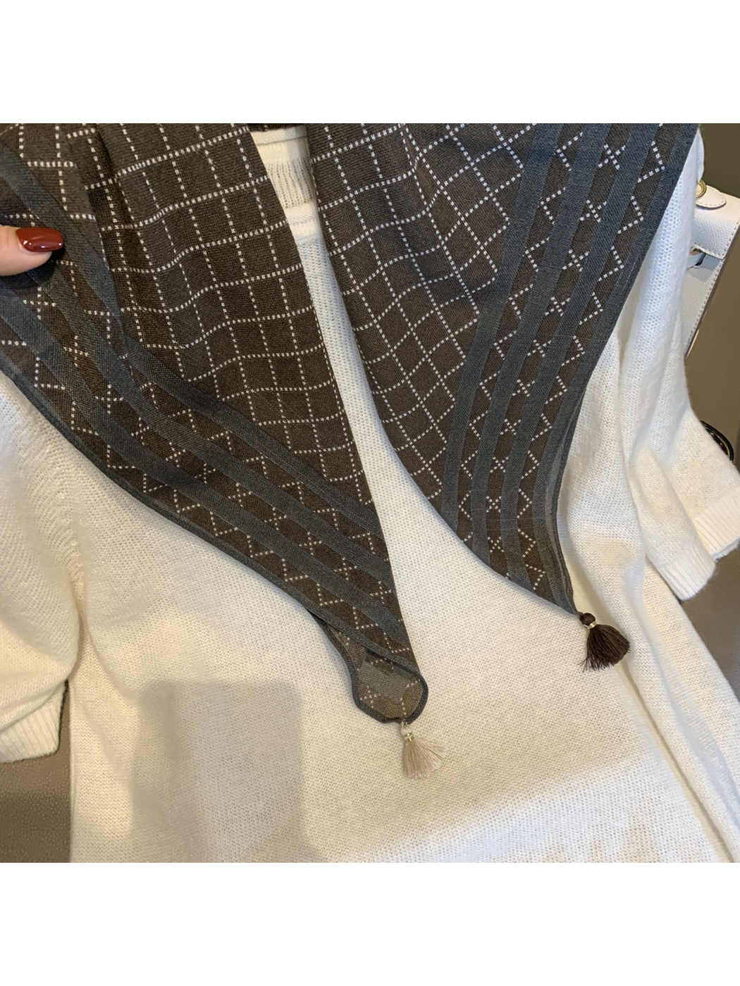 Close-up of the Coffee scarf's striped border and contrasting corner tassels
