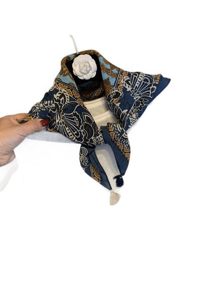 Navy patterned scarf wrapped and tied around a white sweater neckline