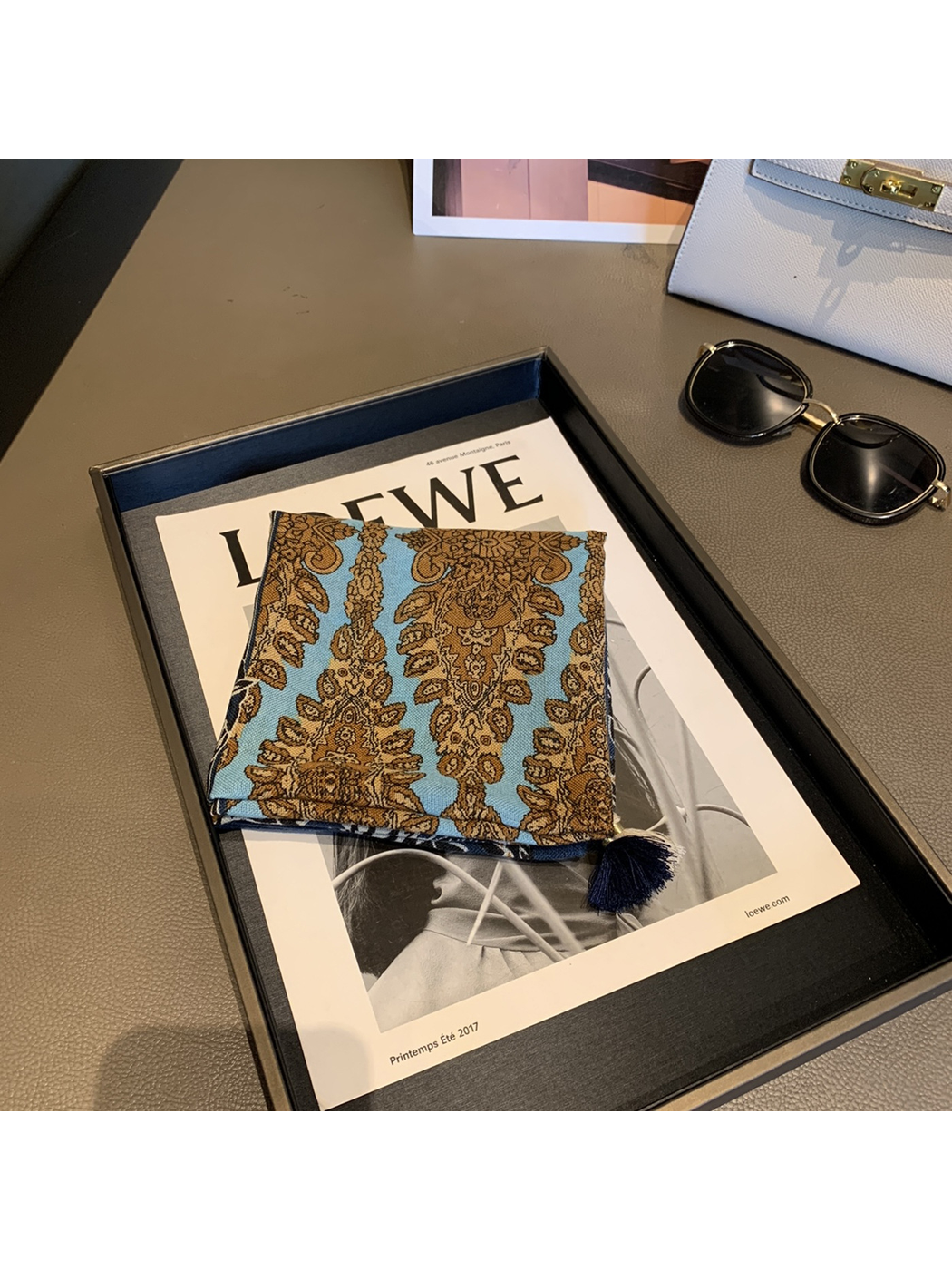 Close view of the light blue and brown ornamental scarf panel and navy tassel