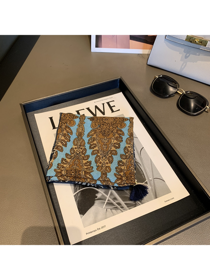 Close view of the light blue and brown ornamental scarf panel and navy tassel