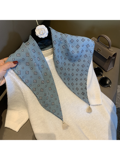 Blue patterned scarf draped over a white sweater