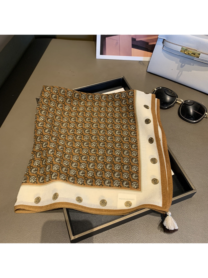 Camel-brown patterned square scarf folded to show the cream medallion border and corner tassels