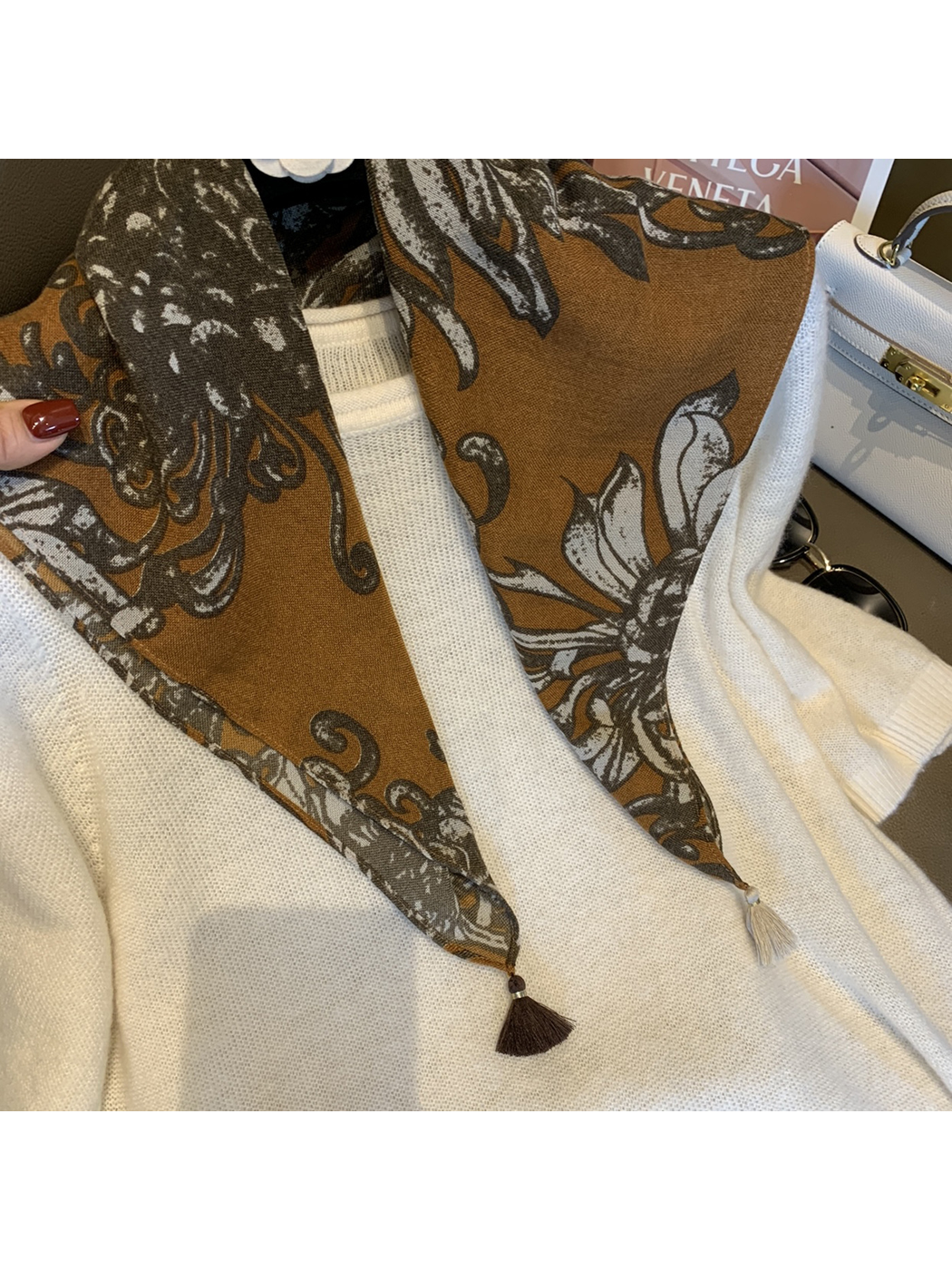 Close-up of the warm brown floral print and two contrasting corner tassels