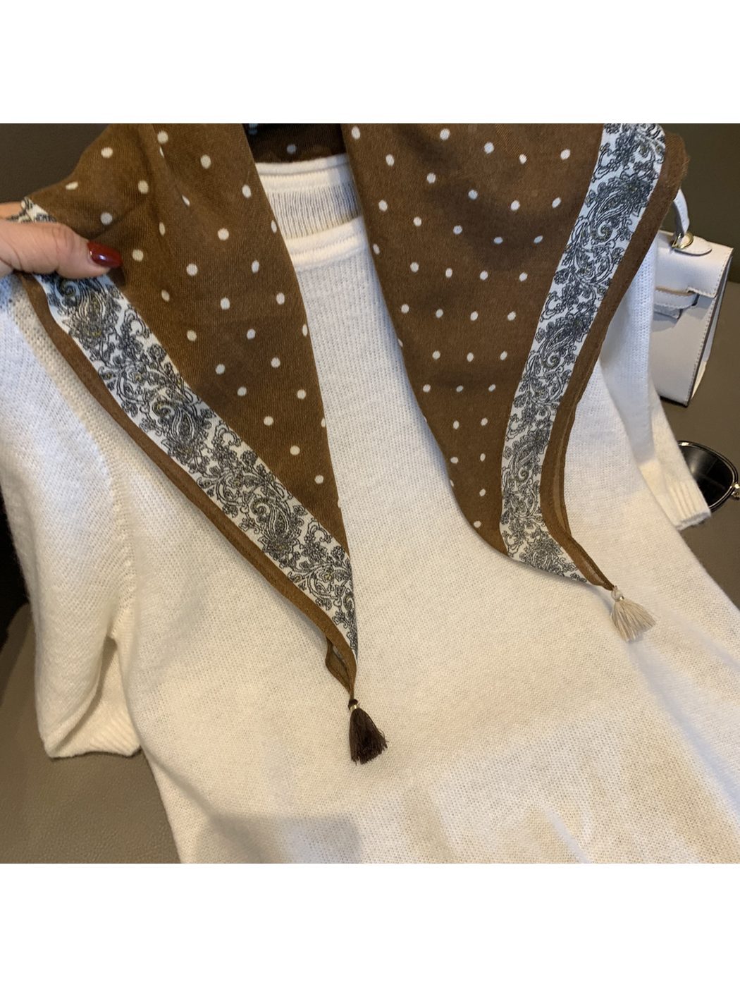 Close-up of the Coffee scarf's polka dots, paisley border and contrasting tassels