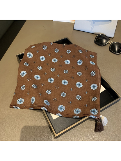 Brown square scarf with floral medallion pattern and contrasting corner tassels, laid flat