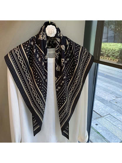 Black Beige paisley and star scarf draped open over a white top