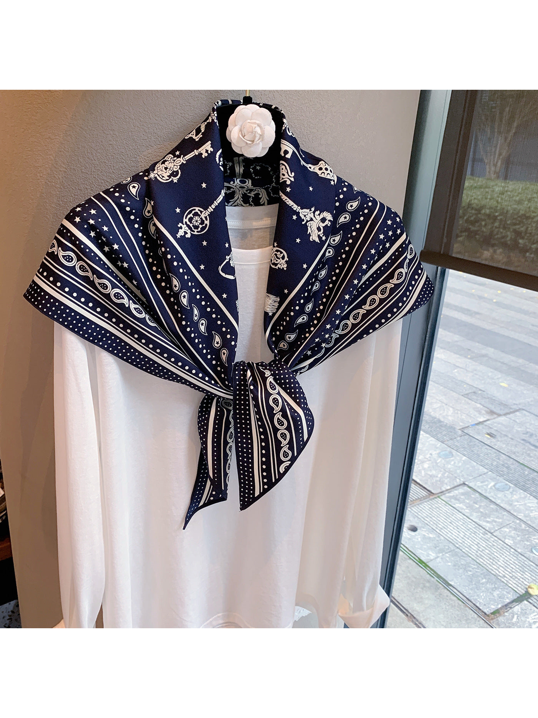 Navy paisley and star scarf tied over a white top