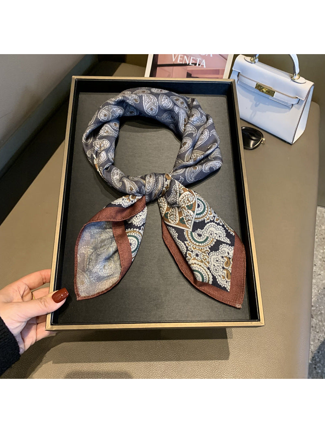 Gray paisley square scarf tied in a loop with brown floral-bordered ends