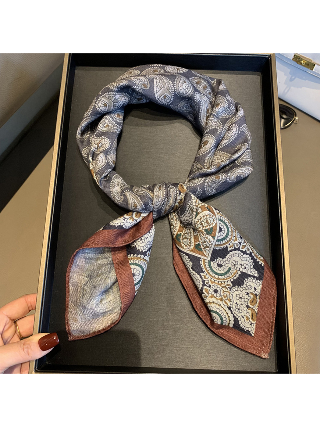 Close-up of the tied scarf with gray paisley loop and floral-bordered ends