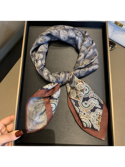 Close-up of the tied scarf with gray paisley loop and floral-bordered ends