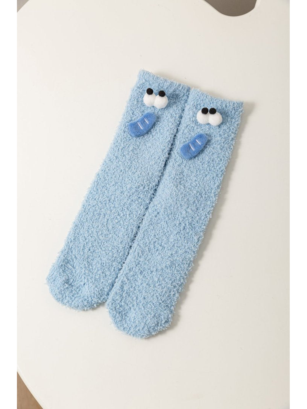 Light Blue fuzzy socks with raised cartoon face appliques